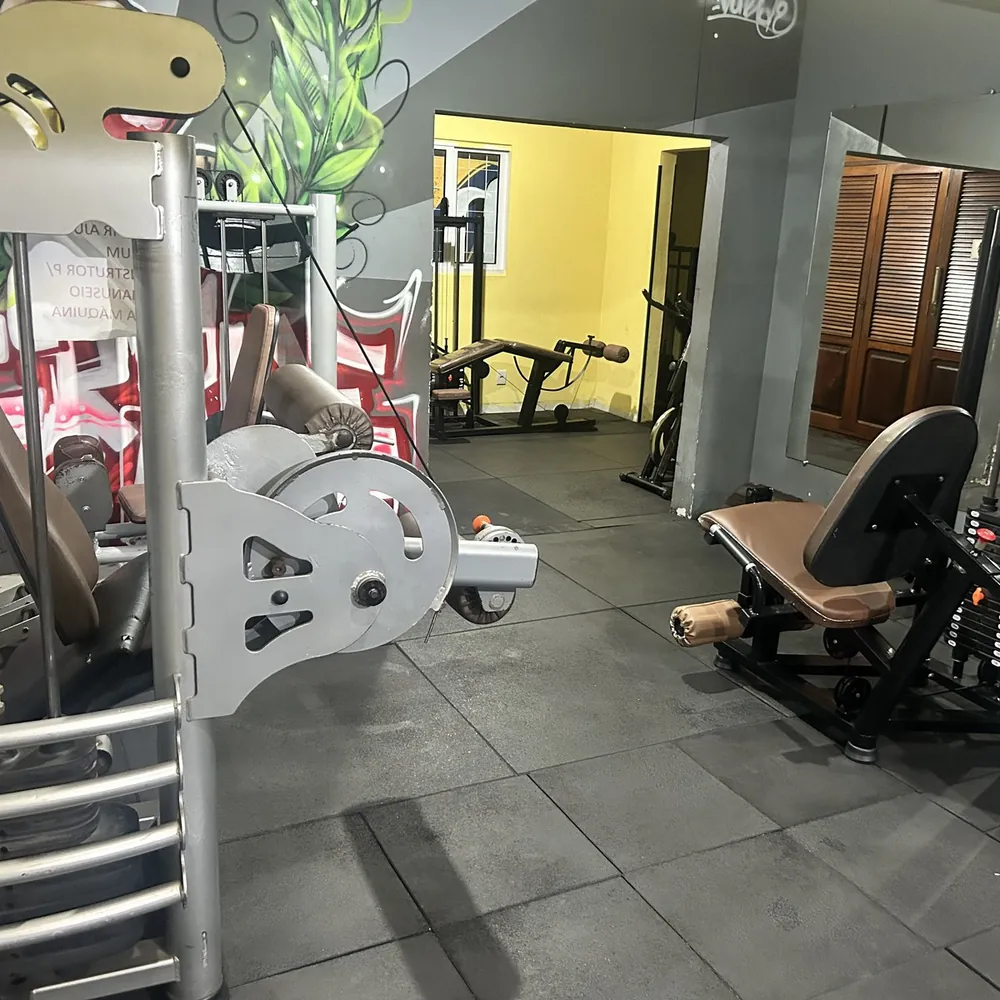 Sala de aparelhos da Academia HomeGym com cadeira extensora e mesa flexora