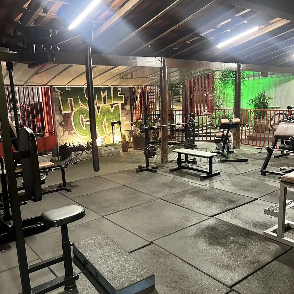 Área coberta de treino ao ar livre da Academia HomeGym, com peso livre e aparelhos