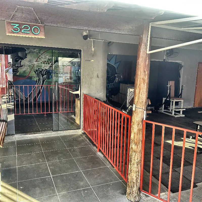 Entrada da Academia HomeGym, número 320, com a sala de musculação ao fundo